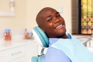 Man smiling in dental chair for dental checkup and teeth cleaning
