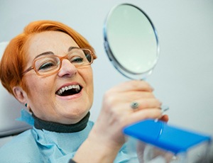 A senior woman admiring her new dentures