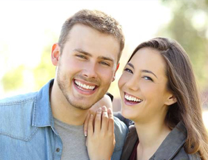 Couple with beautiful teeth after porcelain veneer treatment