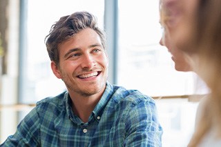 Man in blue shirt smiling at friend