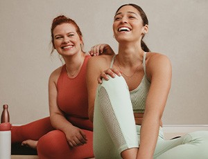 Two friends smiling in exercise class