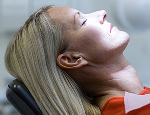 Relaxed woman in dental chair under sedation dentistry