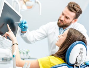 Dentist explaining how dental bridges in Plano work 