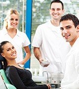 Smiling dental patient and three dental team members