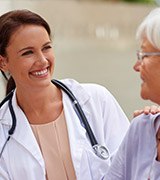 Dentist smiling at elderly patient