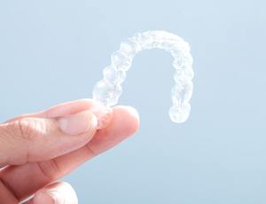 hand holding Invisalign tray