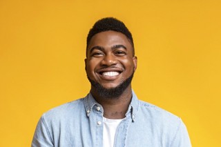 smiling man in front of a yellow background