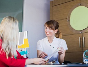 dental team member explaining the cost of dental implants to a patient