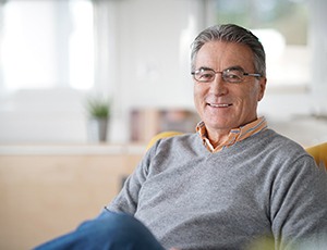Man in grey shirt sitting on the couch