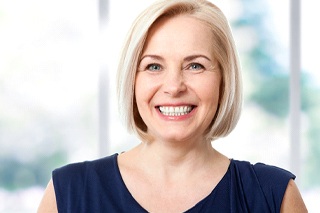 Woman smiling after denture placement