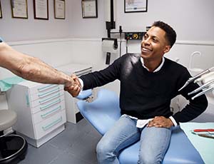 dentist and patient shaking over how to make dental emergencies affordable in Plano