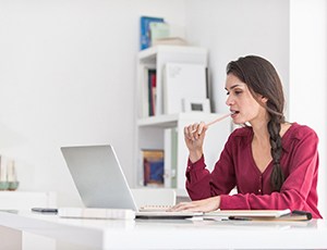 Woman chewing a pencil while working