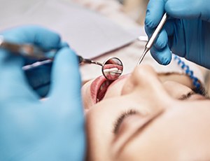 Woman receiving checkup from implant dentist in Plano