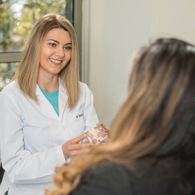 Dentist in Plano showing patient a model of the teeth