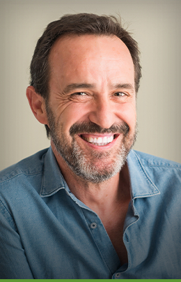 Man smiling and wearing light blue collared shirt