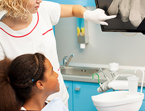 Young girl in dental office looking at x-ray