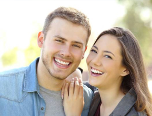 Couple with beautiful teeth after porcelain veneer treatment