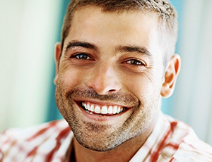 Young man with healthy attractive smile after dental sealant placement