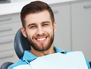 Smiling man under oral conscious dental sedation in dental chair