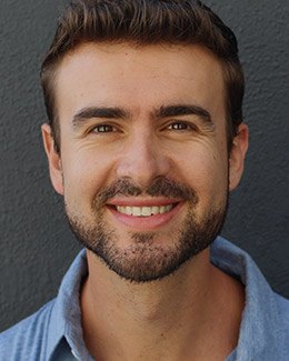 Smiling man in light blue collared shirt