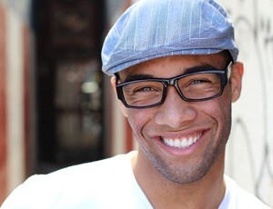 A young man standing outside and smiling after SureSmile aligner treatment