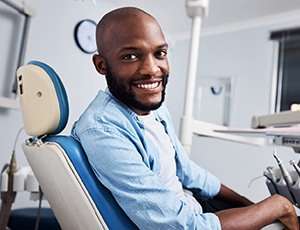 Man sitting in a dental chair and smiling