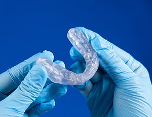 Holding an occlusal splint for TMJ disorder in Plano, TX