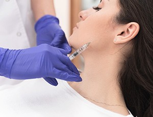 Injecting BOTOX in a woman’s jaw 