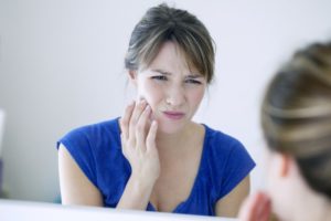 woman in blue shirt who needs emergency dentist in Plano