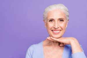 Smiling woman with implant-retained dentures in Plano