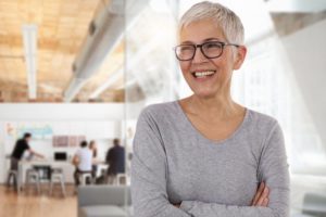 smiling woman with implant dentures in Plano 